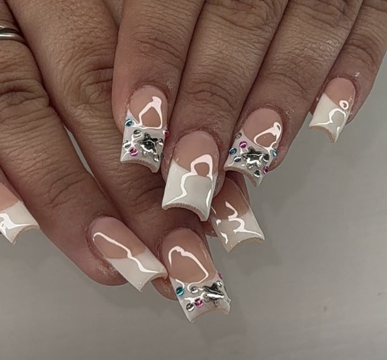 Square nails with white swirl French tips, silver charms and crystal accents